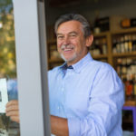 66841728 – wine shop owner holding open sign